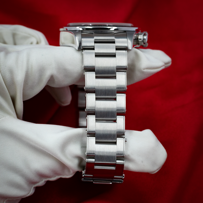 Tudor Black Bay Chrono M79360N-0002 side view, watch case and metal bracelet in a gloved hand.