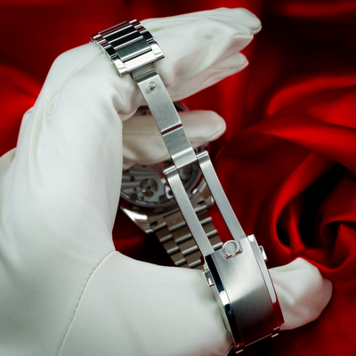 Omega Speedmaster 57 Chronograph 332.10.41.51.10.001, stainless steel deployant clasp detail, held by gloved hand.