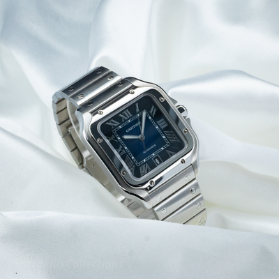 Cartier Santos WSSA0063 watch with blue dial and date window on steel bracelet, angled view.