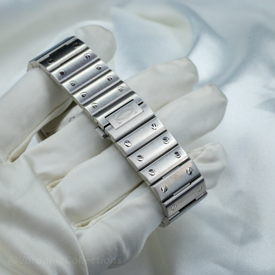 Cartier Santos WSSA0063, metal bracelet clasp with logo, held in a white gloved hand.