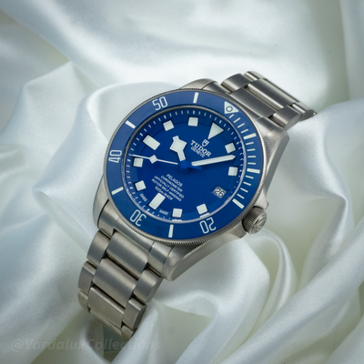 Tudor Pelagos Blue Titanium M25600TB-0001, full dial view with date window and titanium bracelet on white fabric.