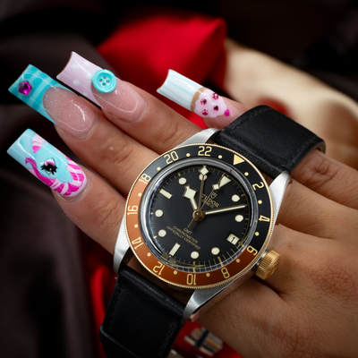 Tudor Black Bay Gmt S&g M79833MN-0003 wrist shot, showing the dial, bezel, gold crown, and leather strap.