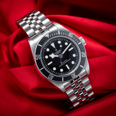 Tudor Black Bay 41mm M7941A1A0NU-0003, full watch dial, bezel, and jubilee bracelet on red fabric.