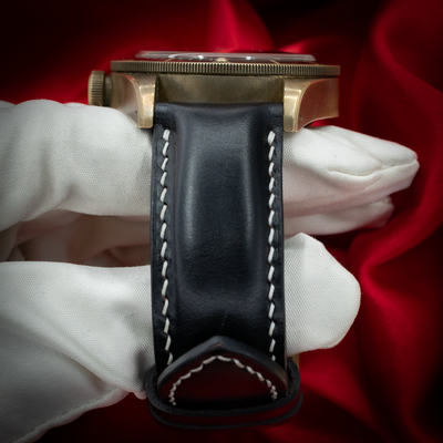 Tudor Black Bay M79250BA-0001, top-down view of the watch on a gloved hand with black leather strap.
