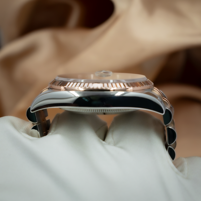 Rolex Datejust 36 116231 side view showing rose gold fluted bezel, cyclops lens, and steel case.