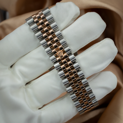 Rolex Datejust 36 116231 bracelet with Oysterclasp, showing rose gold and steel links on a white-gloved hand.