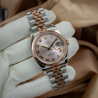 Rolex Datejust 36 116231 dial, rose gold fluted bezel, Roman numerals, and two-tone Jubilee bracelet on a gloved hand.