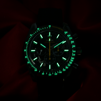 Omega Speedmaster Dark Side Of The Moon 311.92.44.30.01.001 dial with luminous hands and markers glowing green in the dark.
