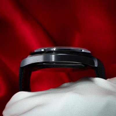 Omega Speedmaster Dark Side Of The Moon 311.92.44.30.01.001, side view of the black ceramic case on white fabric.