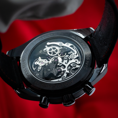 Omega Speedmaster Dark Side Of The Moon 311.92.44.30.01.001 exhibition caseback showing movement gears and text engraving.