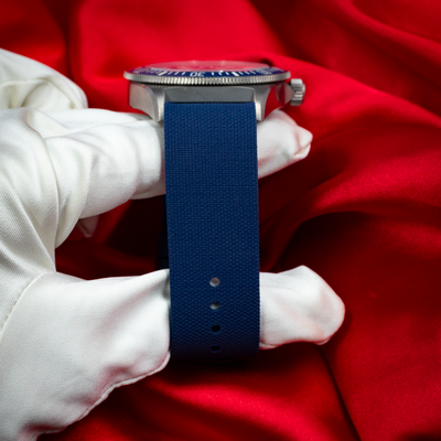 Tudor Pelagos FXD Marine Nationale 25707B/23-0001 case side with blue strap on gloved hand.