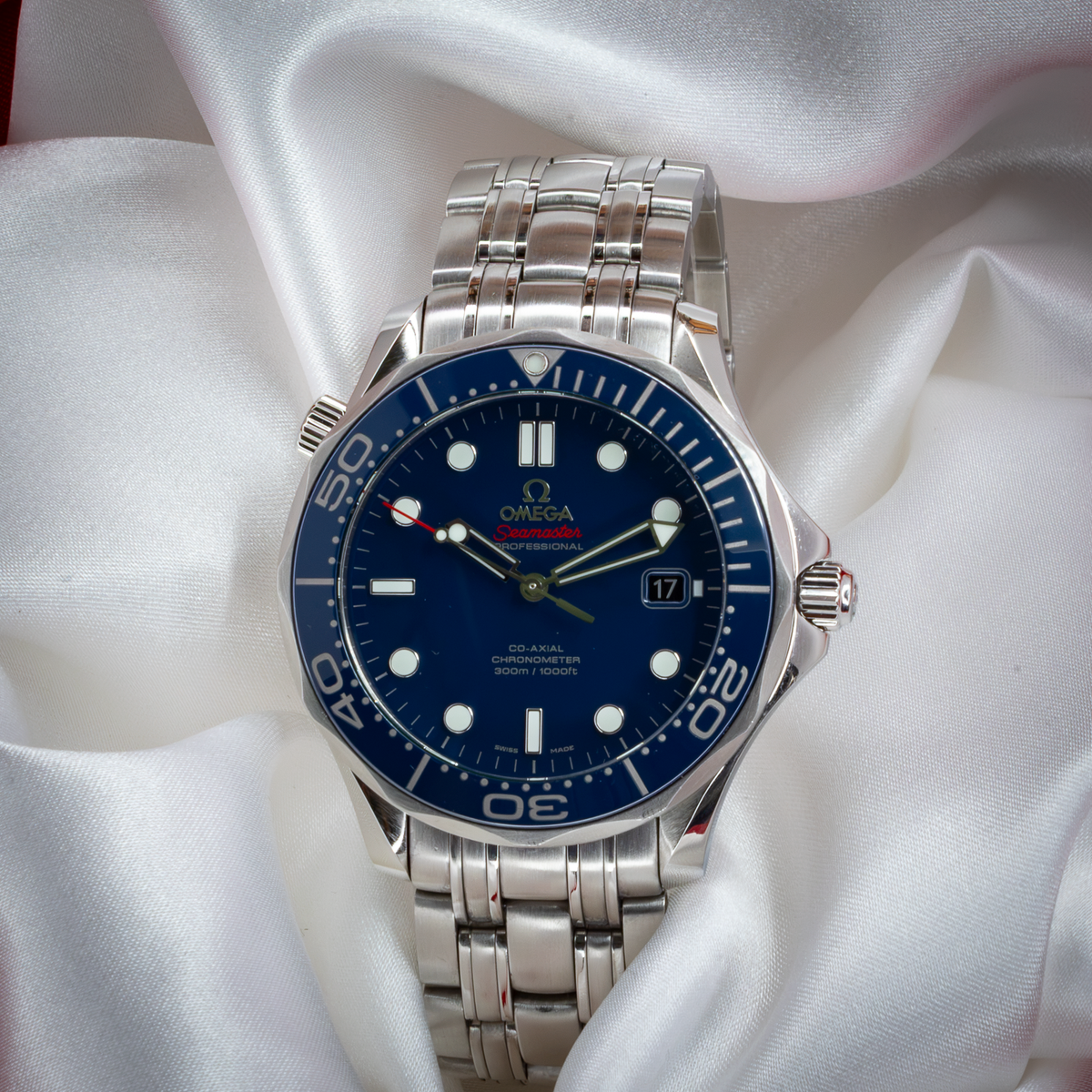 Omega Seamaster Diver 212.30.41.20.03.001 watch with blue dial and steel bracelet, visible from above on white silk.