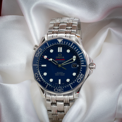 Omega Seamaster Diver 212.30.41.20.03.001 watch with blue dial and steel bracelet, visible from above on white silk.