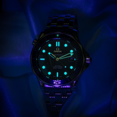 Omega Seamaster Diver 212.30.41.20.03.001 dial with glowing luminescent hour markers, hands, and bezel pip.