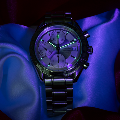 Omega Speedmaster Date 3513.30.00 dial, glowing green lume and date window.