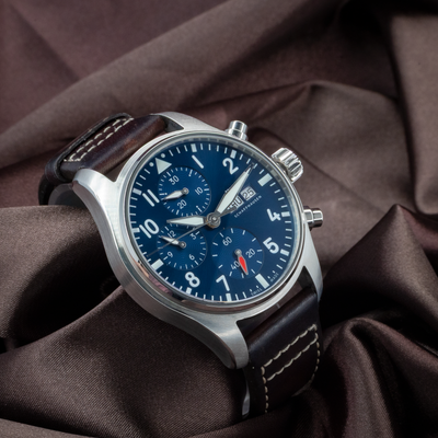IWC Pilot Chronograph IW388101, blue dial with day-date, chronograph subdials, and brown leather strap.