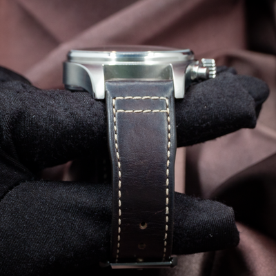 IWC Pilot Chronograph IW388101, side case, crown, and dark brown leather strap with stitching on wrist.