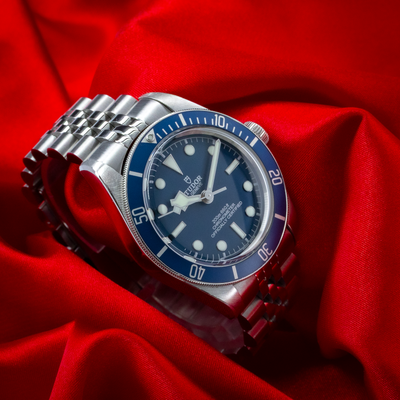 Tudor Black Bay Fifty-Eight Blue M79030B-0001, full dial, bezel, crown, and jubilee-style bracelet view on red fabric.