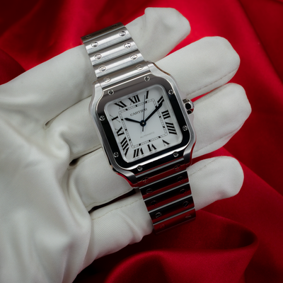 Cartier Santos De Cartier WSSA0029, a close-up of the watch held by a gloved hand showing the dial and bracelet.