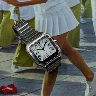 Cartier Santos De Cartier WSSA0029 watch dial and bracelet on a vibrant background.