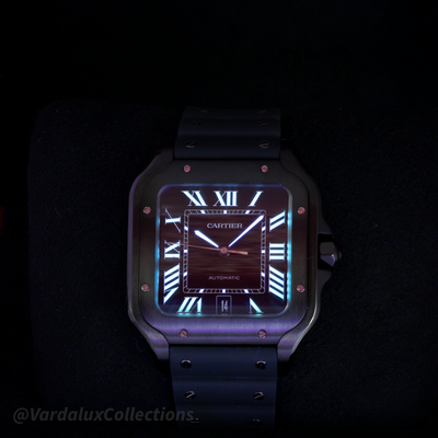 Cartier Santos De Cartier WSSA0039 watch, luminous dial and hands on a dark background.