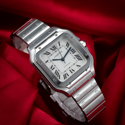 Cartier Santos De Cartier White Dial WSSA0029, full dial view with blue hands and bracelet on red cloth.