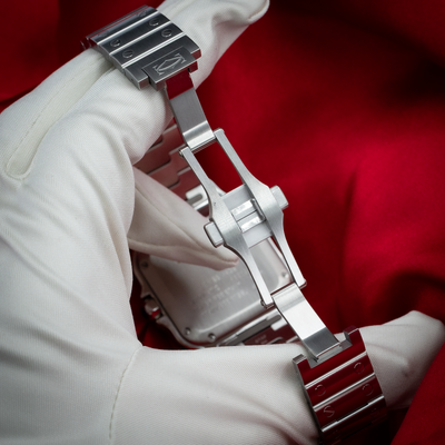 Cartier Santos De Cartier White Dial WSSA0029, a white-gloved hand holds the watch showing the polished and brushed metal