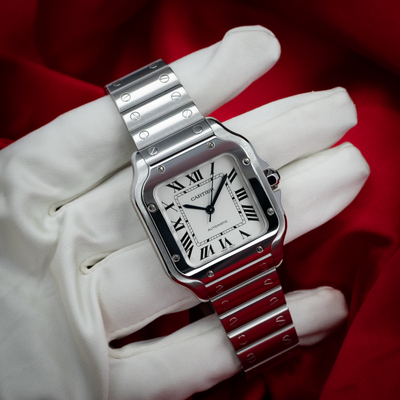 Cartier Santos De Cartier White Dial WSSA0029, full top-down view of dial and bracelet on white-gloved hand.