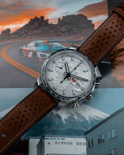 Chopard Mille Miglia Gts Race Edition 2022 168571-3010 dial with brown perforated strap and race-themed background.