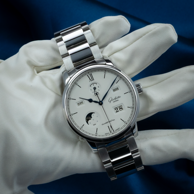 Glashütte Original Senator Excellence 1-36-02-01-02-61 dial with moon phase, day, month, and date, held by a gloved hand.