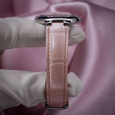 Cartier ballon bleu wsbb0002, side view of pink alligator leather strap with polished case held by gloved hand.
