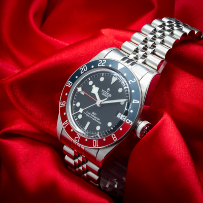 Tudor Black Bay GMT 79830RB, full dial view with jubilee bracelet on red satin.