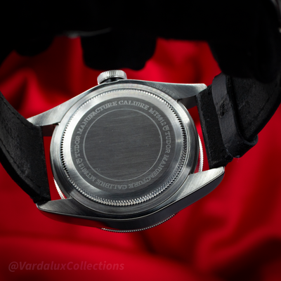 Tudor Black Bay 79730-0005 caseback with brushed steel and engraved text, on a red background.