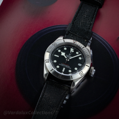 Tudor Black Bay 79730-0005, a top-down view of the watch dial, bezel, and leather strap.