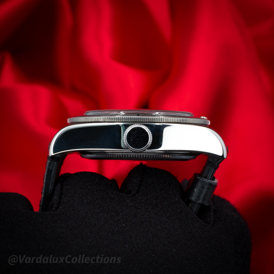Tudor Black Bay 79730-0005 case and crown side view with a red background.