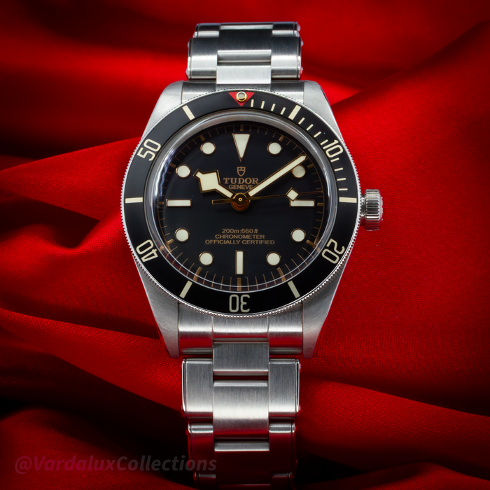 Tudor Black Bay Fifty-Eight M79030N-0001, full dial view with stainless steel bracelet on red background.