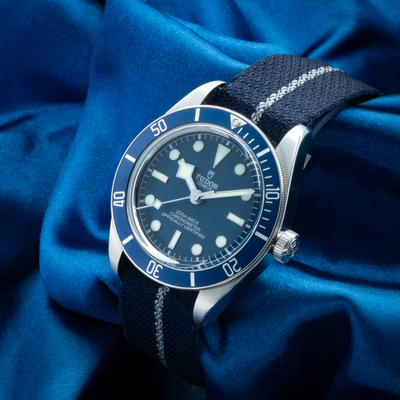 Tudor Black Bay Fifty-eight Blue M79030B-0003, close-up of blue dial and bezel on striped fabric strap.