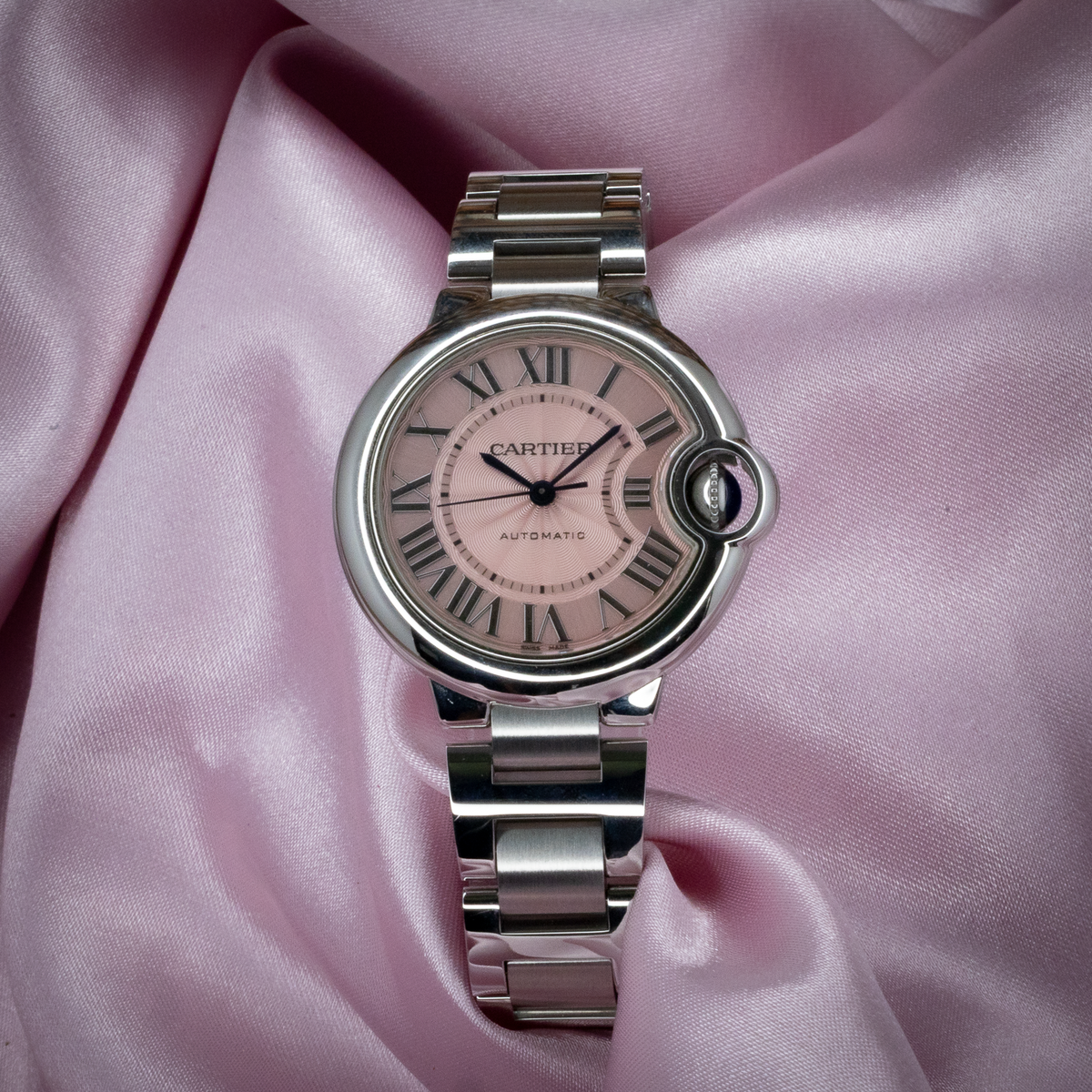 Cartier Ballon Bleu W6920100 pink dial and steel bracelet, top-down view.