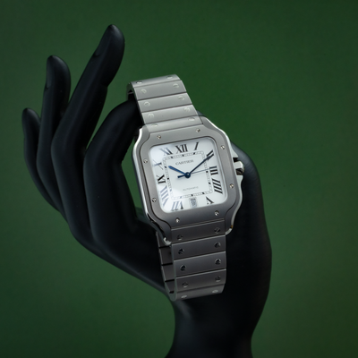 Cartier Santos WSSA0089 wrist shot on a black mannequin, showing the silver square case and white dial with Roman numerals.