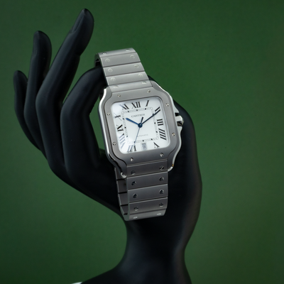 Cartier Santos WSSA0089 dial on a black mannequin hand, with a silver case and bracelet.