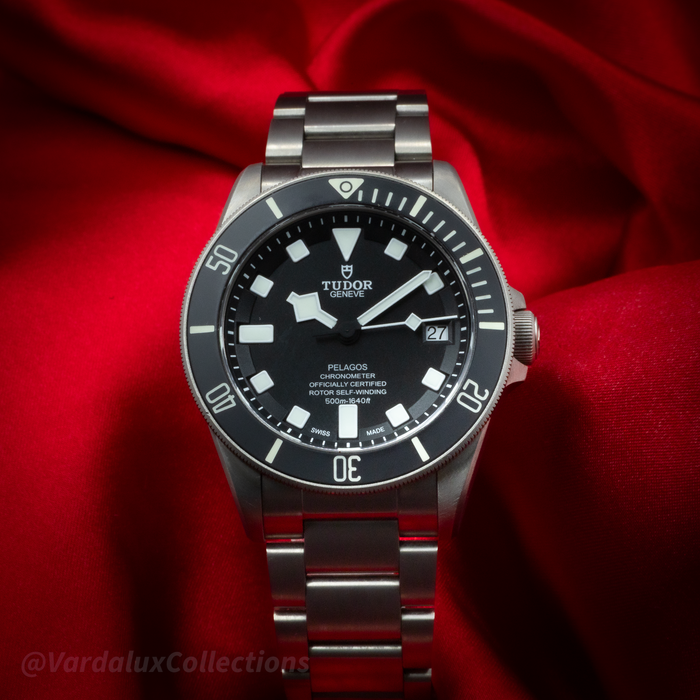 Tudor Pelagos 25600TN watch, black dial with white markers and hands, date window at 3 o'clock, on metal bracelet.