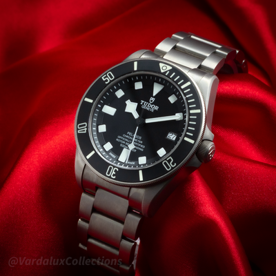 Tudor Pelagos 25600TN dial, bezel, and titanium bracelet on a red fabric background.