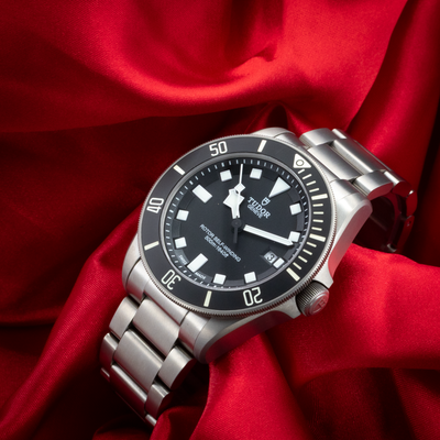 Tudor Pelagos 25500TN dial and bracelet view against a red fabric.