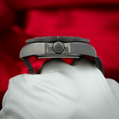 Tudor Pelagos 25500TN, side case view showing crown with shield logo and bezel edge on white glove.