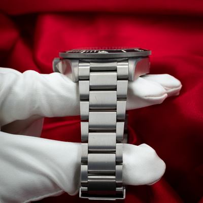 Tudor Pelagos 25500TN side profile of watch case, crown, and titanium bracelet links held by a gloved hand.
