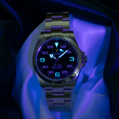 Rolex Air King Automatic Black Dial 126900 dial with glowing lume under UV light.