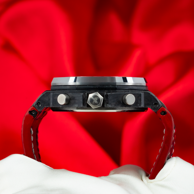 Audemars Piguet Jarno Trulli 26202AU.OO.D002CA.01, side view of case, crown, pushers, and red strap.