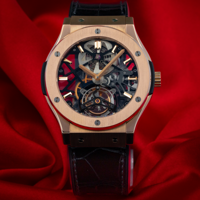 Hublot Gold Skeleton 505.OX.0180.LR, full dial view with rose gold case and black alligator strap on red silk.