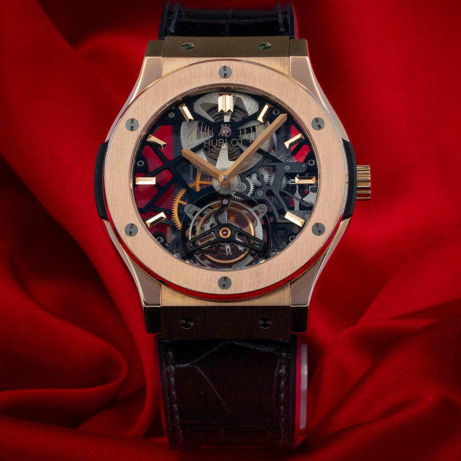 Hublot Gold Skeleton 505.OX.0180.LR, full dial view with rose gold case and black alligator strap on red silk.