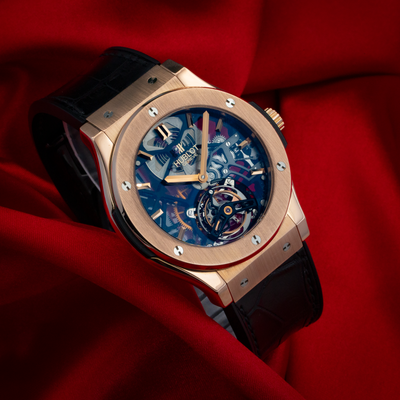 Hublot Gold Skeleton 505.OX.0180.LR, rose gold case, visible skeleton dial with blue and red details, and black leather
